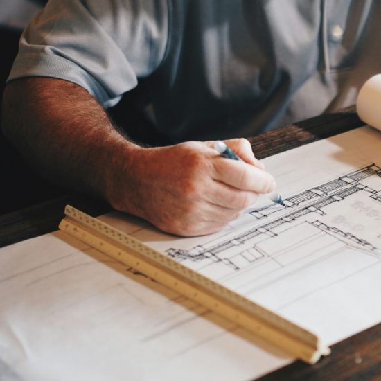 Architect reviewing construction drawings and project plans at drafting table
